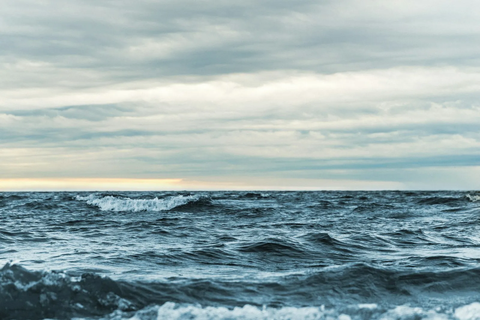 Landscape photo of ocean waves under heavy clouds