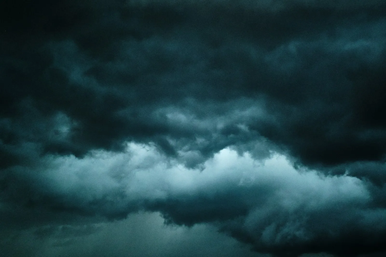 A plane flying through a dark, cloudy sky