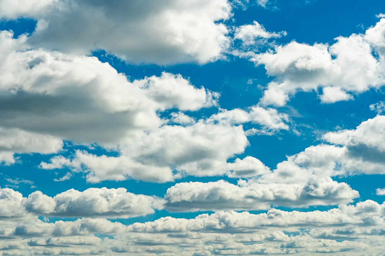 White clouds drifting across a pale sky