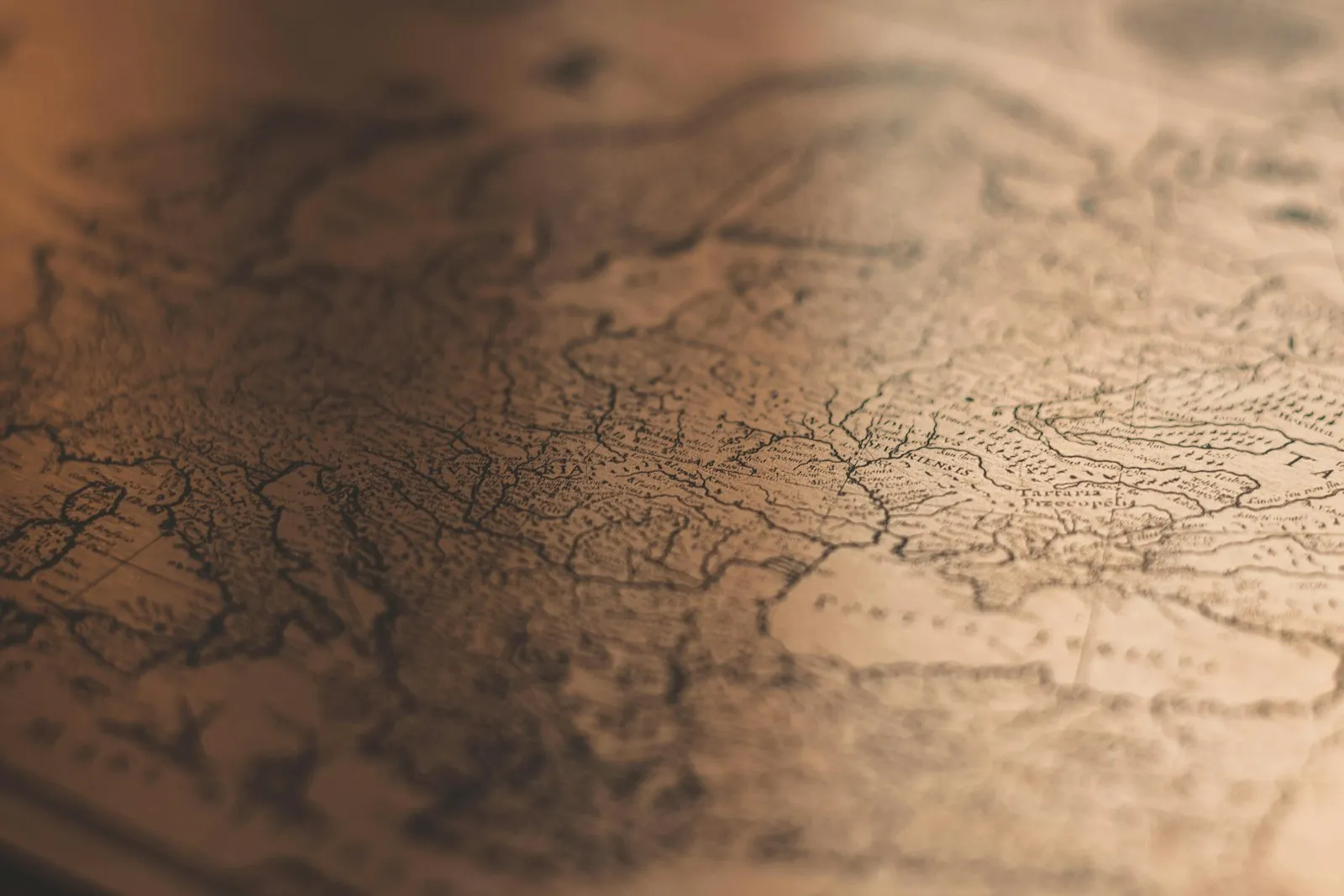 Close-up of an antique paper map in warm, soft-focus light