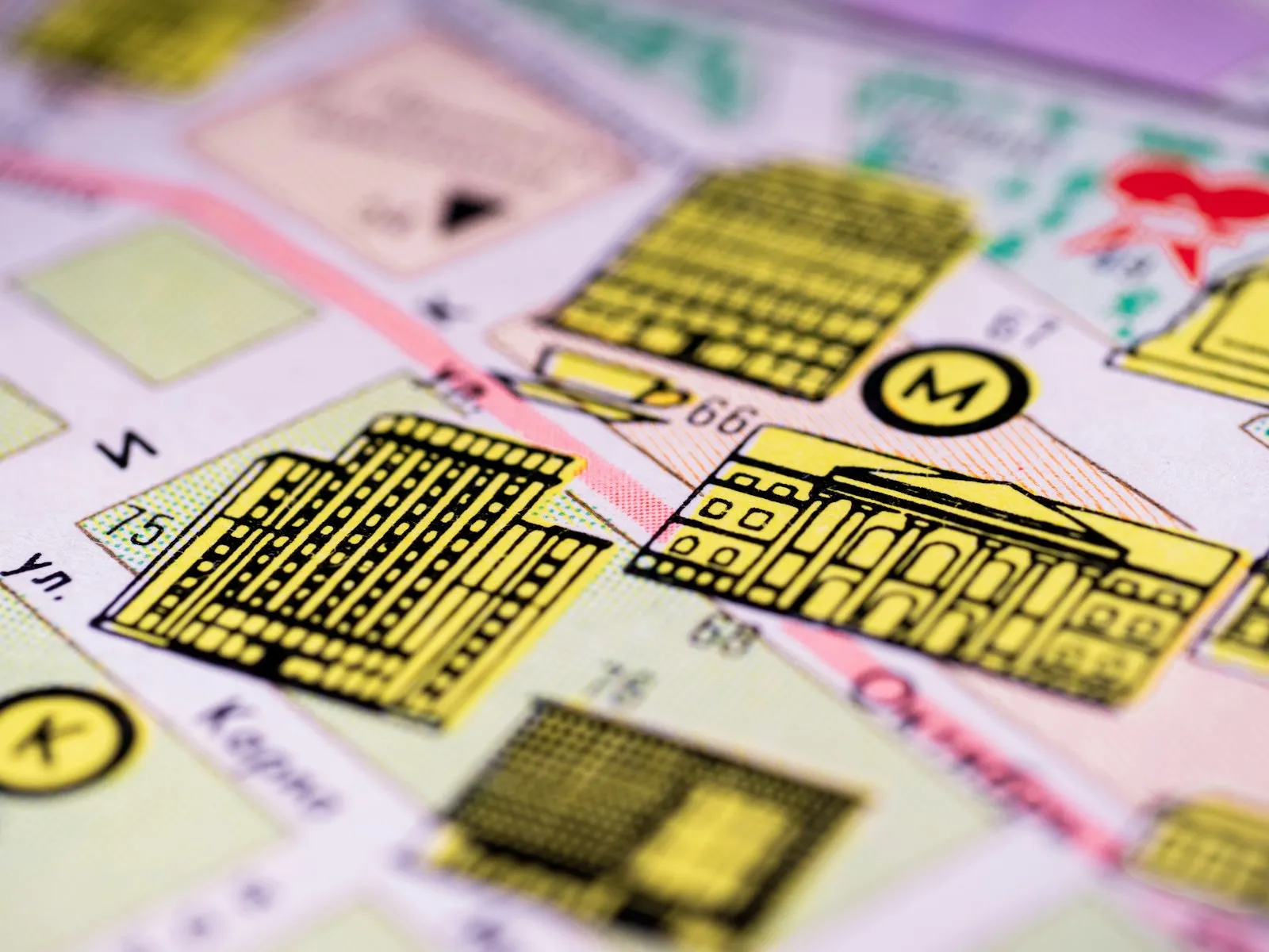 Close-up of a printed city map with yellow building drawings, a metro symbol and street names