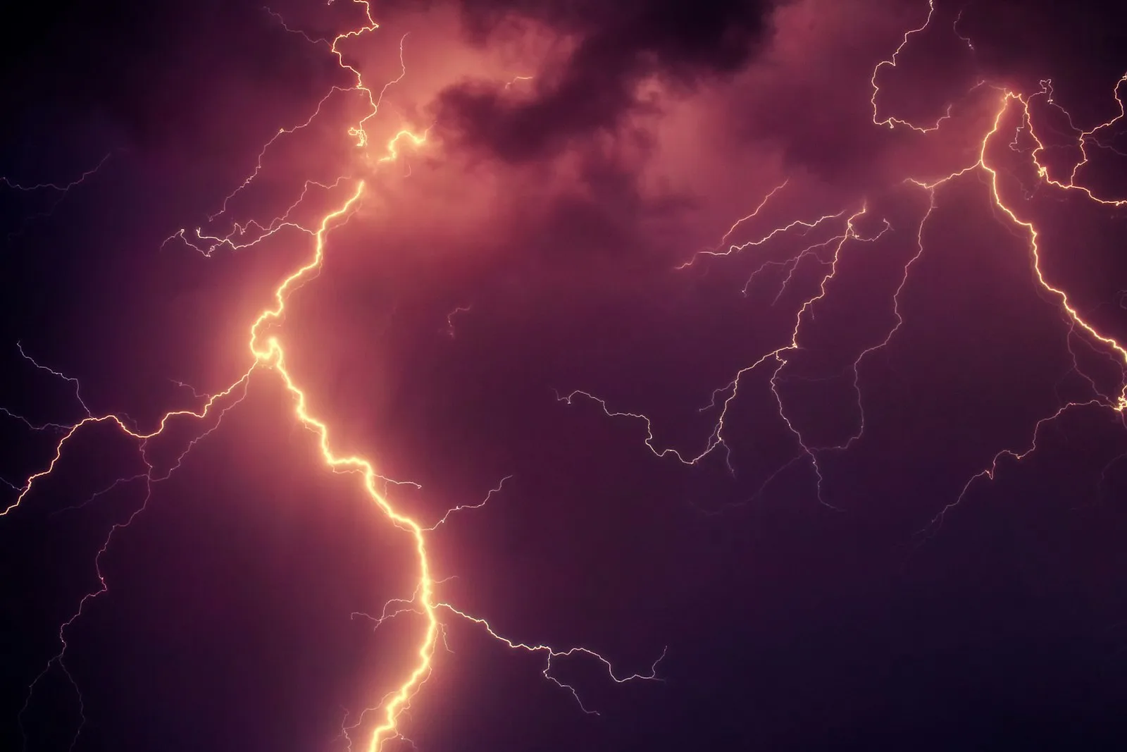 Time-lapse photo of lightning striking across a night sky