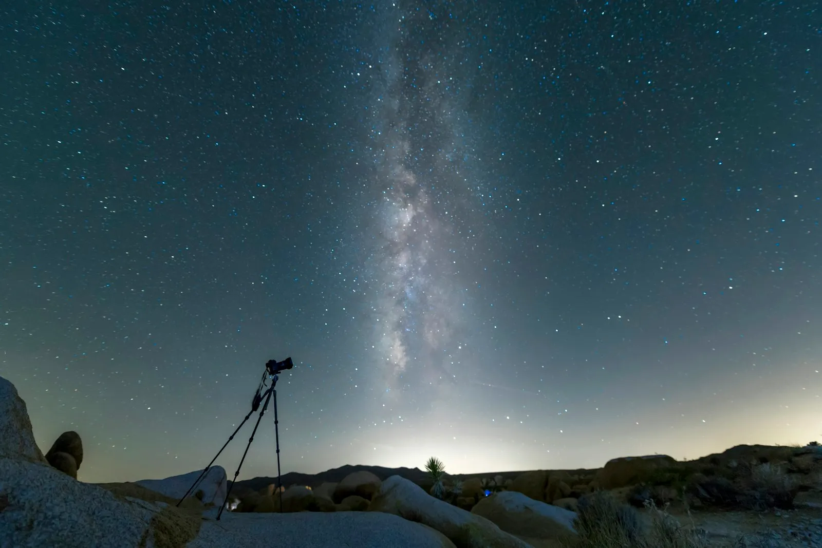Black tripod on snow-covered ground under a starry night sky