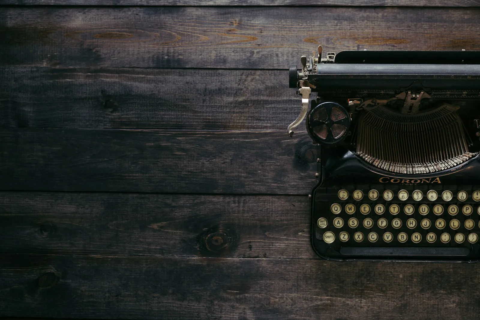 Black Corona typewriter on brown wooden planks